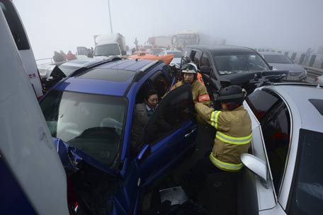 Firefighters rescue a flight attendant from a damaged vehicle on Yeongjong Bridge in Incheon