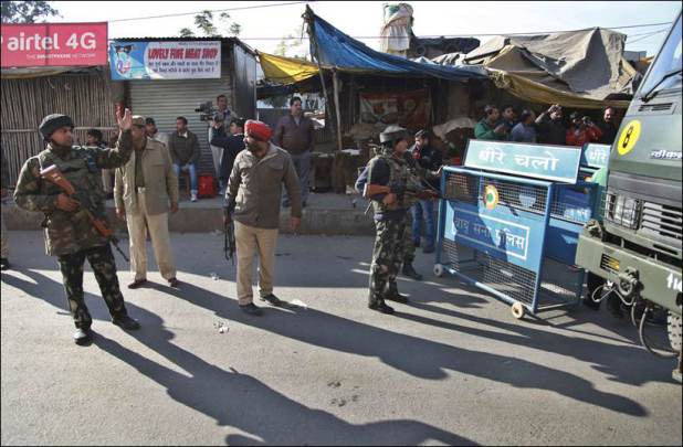 Indian security forces man a road barrier outside an Indian air force base in Pathankot, 430 kilometers (267 miles) north of New Delhi, India, Saturday, Jan. 2, 2016. Gunmen attacked the air force base near the border with Pakistan on Saturday morning and exchanged fire with security forces, officials said. (AP Photo/Channi Anand)