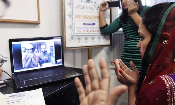 Punam Chowdhury prays during her Skype wedding with Tanvire Ahmmed, who is in Bangladesh, at the New York Qazi Office in New York, Feb. 14, 2013. In some immigrant communities, couples are marrying by proxy over the Internet, a practice so new that immigration authorities say they do not typically screen for it in their efforts to detect marriage fraud. (Niko J. Kallianiotis/The New York Times)