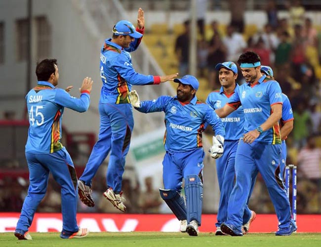 Afghanistan's players celebrate after the wicket of West Indies's batsman Andre Russell during the World T20 cricket tournament match between West Indies and Afghanistan at The Vidarbha Cricket Association Stadium in Nagpur on March 27, 2016. / AFP / PUNIT PARANJPE