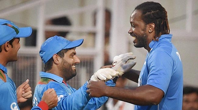Nagpur: Afghanistan wicket keeper Mohammad Shahzad with West Indies player Chris Gayle after victory over West Indies during the ICC T20 World cup match played in Nagpur on Sunday. PTI Photo by Shashank Parade(PTI3_27_2016_000147A)