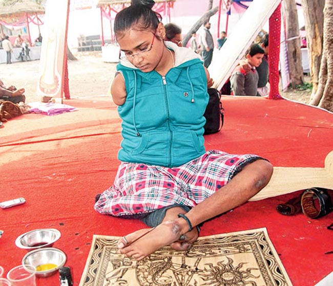 Sarita Dwivedi, who lost her right leg and two hands in an accident at the age of 4, busy in making a Madhubani painting in Shilpotsav, the  ongoing art exhibition organised by Upendra Maharathi Shilp Anusandhan Sansthan in Patna on Friday Pix by Nagendra Kumar Singh Story by Shuchi