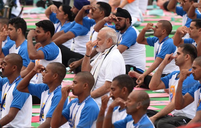 Indian Prime Minister Narendra Modi (C) participates in a mass yoga session along with other Indian yoga practitioners to mark the 2nd International Yoga Day at Captol complex in Chandigarh on June 21, 2016. / AFP PHOTO / PRAKASH SINGH